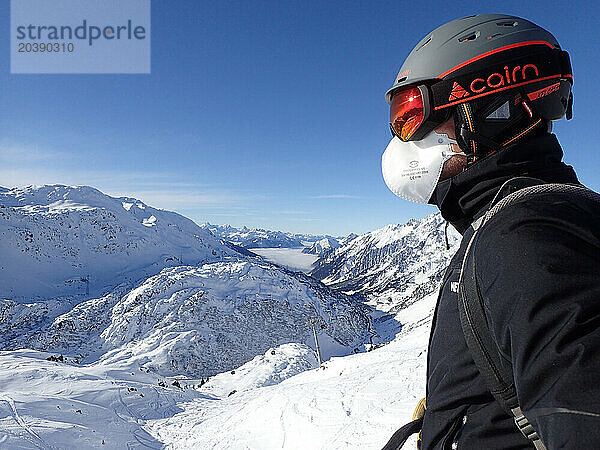 Autriche  Tyrol  station de ski de Sankt Anton am Arlberg   un homme porte un casque de ski  des lunettes de soleil et un masque de protection COVID FFP2 / Austria  Tyrol  Sankt Anton am Arlberg ski resort   a man wears a ski helmet  sun glasses and a covid protection mask FFP2