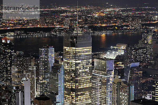 USA. New York City. Manhattan. Empire State Building. View from the top of the building at dusk and night  in direction of the east. The East river is visible in the background.