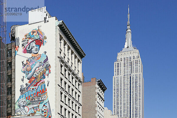 USA. New York City. Manhattan. Empire State Building. View from the streets. Street art is visible in the foreground.