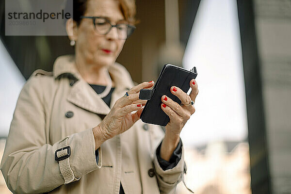 Low angle view of retired senior woman using smart phone