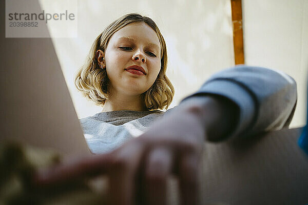 Low angle view of volunteer searching in box during charity drive at community center