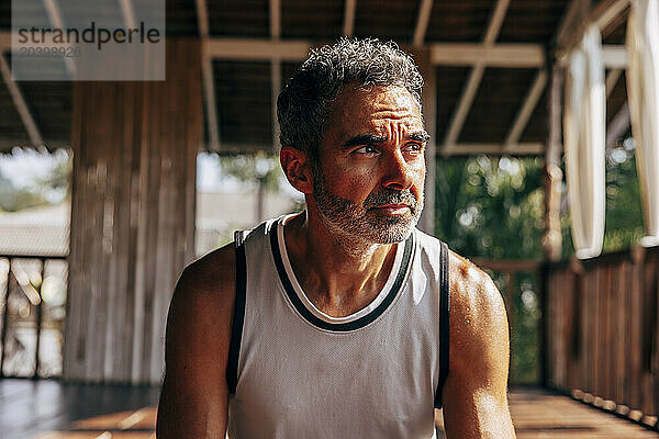 Thoughtful mature man looking away at wellness resort