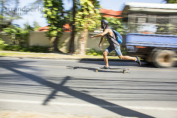 Blurred motion on young man longboard on road