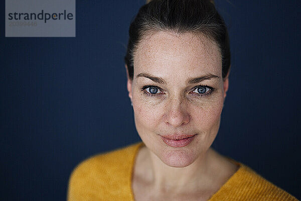 Confident beautiful mature woman against colored background