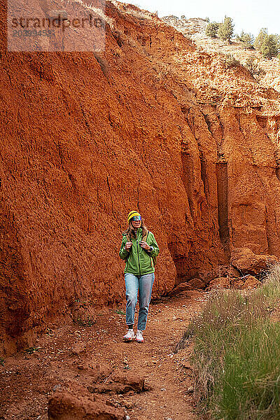 Mature woman hiking through red canyon