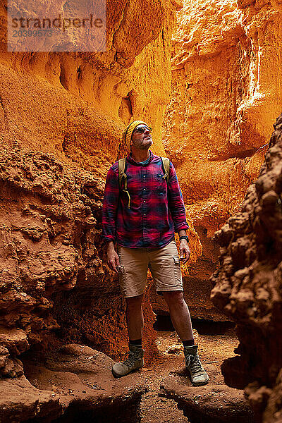 Mature man looking around in red canyon