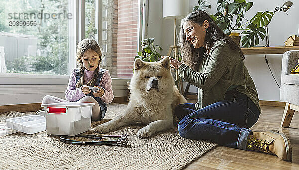 Grandmother and granddaughter sitting with dog at home