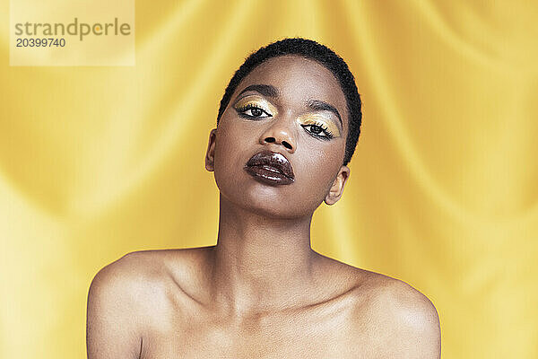 Beautiful woman with make-up against yellow background