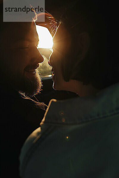 Couple kissing in car at sunset