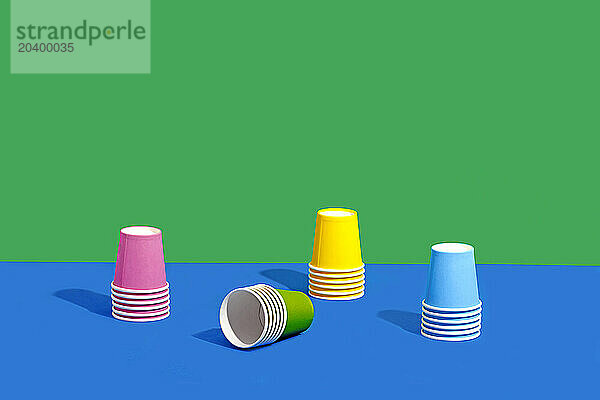 Colorful paper cups stacked against two tone colored background