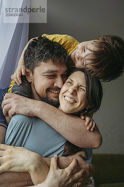 Happy family embracing each other at home