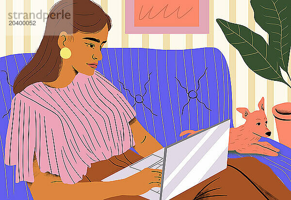 Woman working on laptop by dog relaxing on sofa at home