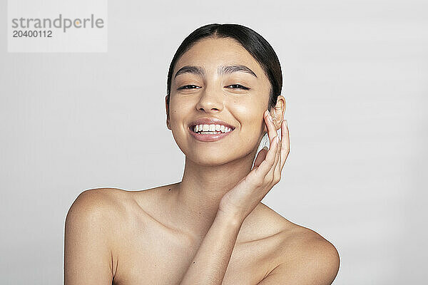 Happy beautiful young naked woman against white background