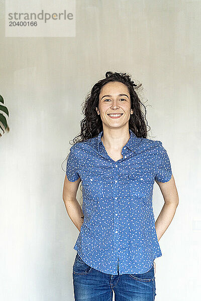 Smiling woman standing in front of wall