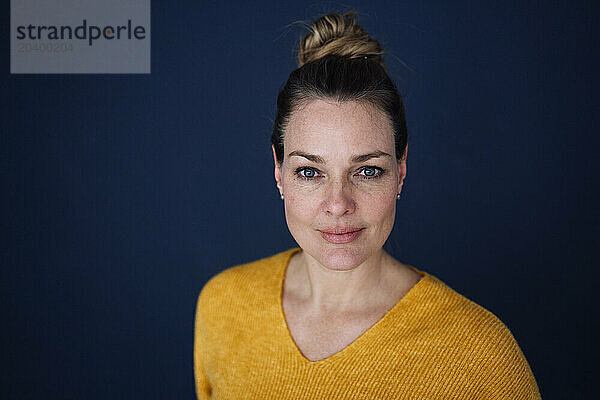 Confident beautiful woman against colored background