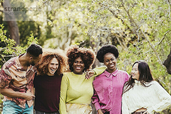 Smiling multiracial friends spending leisure time at park