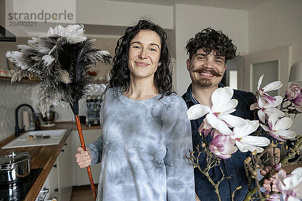 Smiling couple standing in kitchen at home