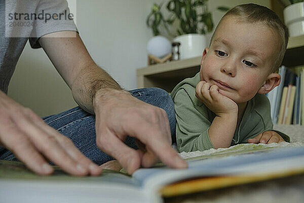 Father and son reading book at home