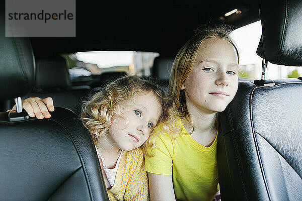 Blond sisters sitting in car