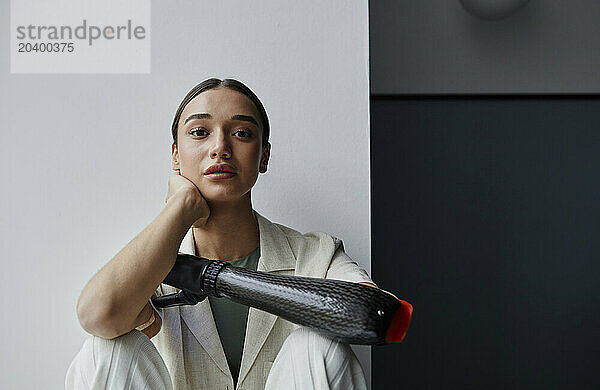 Young woman with black bionic arm at home