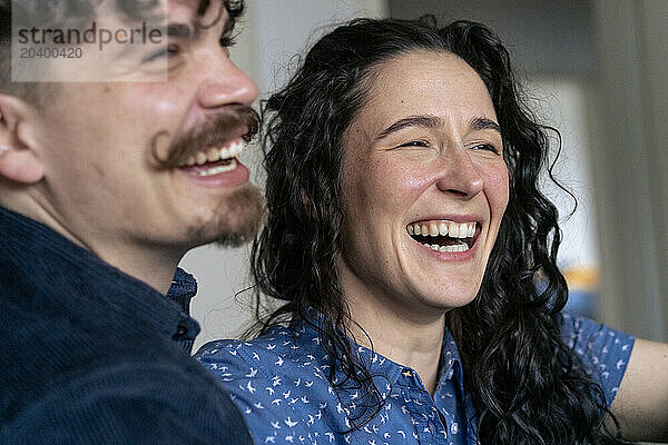 Happy woman laughing with boyfriend at home