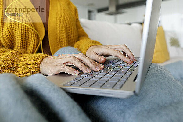 Hands of freelancer typing on laptop at home office