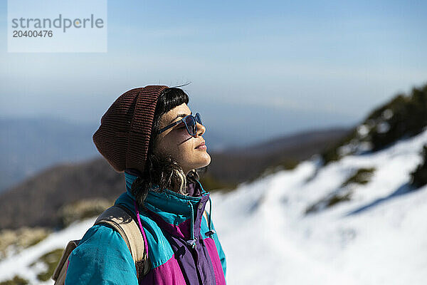 Young woman in sunglasses on snowy mountain