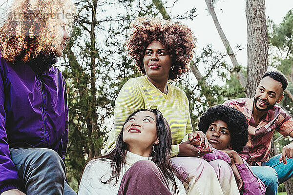 Woman talking with multiracial friends at park