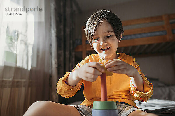 Happy boy playing with educational game at home