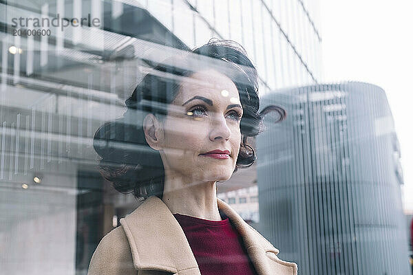 Focused businesswoman behind glass window