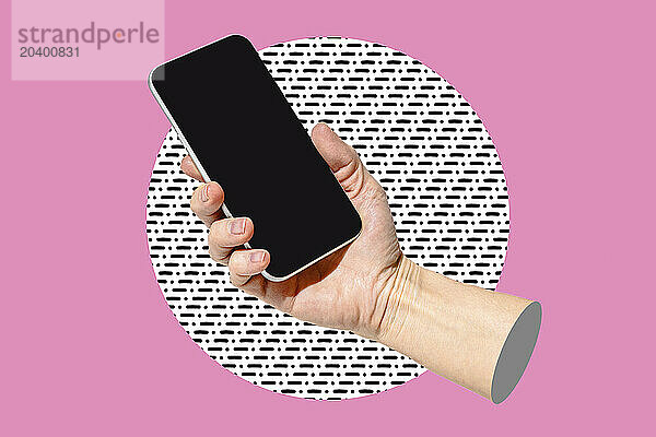 Hand of woman holding blank screen smart phone against colored background