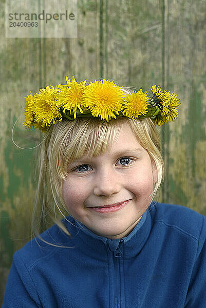 Smiling girl wearing tiara made of dandelions