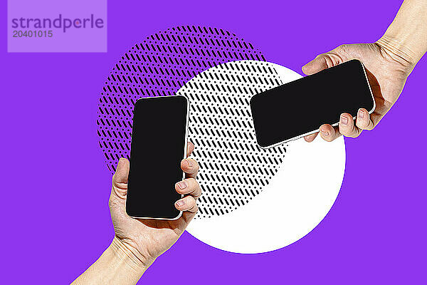 Two hands holding smart phones over violet background