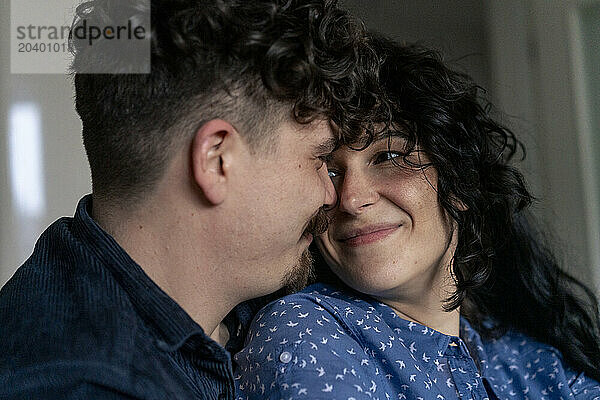 Affectionate couple looking at each other in home