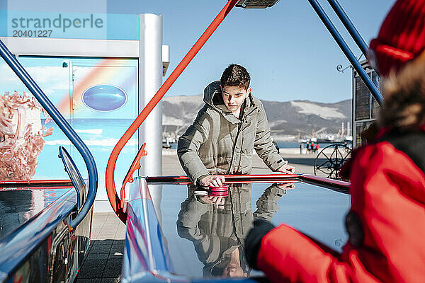 Boy competing with brother in air hockey