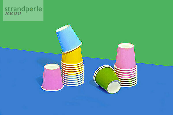 Colorful still life of disposable paper cups on two tone colored background