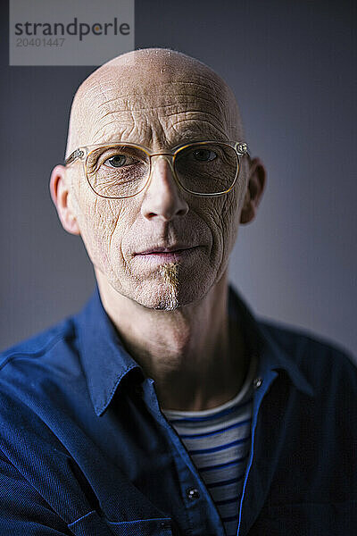 Senior man with shaved head wearing eyeglasses