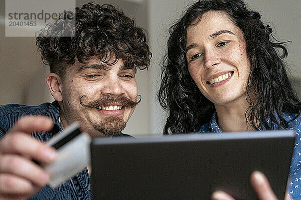 Smiling couple doing online shopping at home