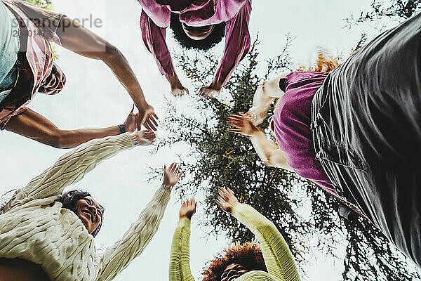 Happy multiracial friends celebrating together at park