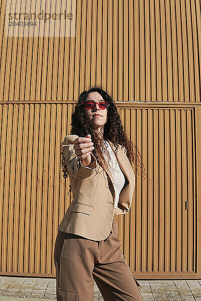 Confident woman gesturing on sunny day