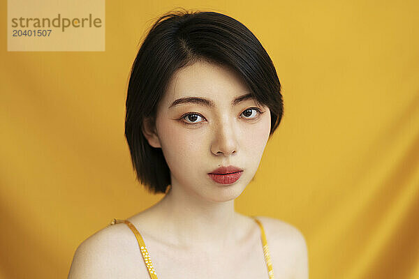 Beautiful woman with short hair against yellow background