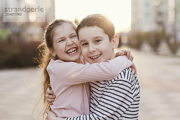 Cheerful siblings embracing each other