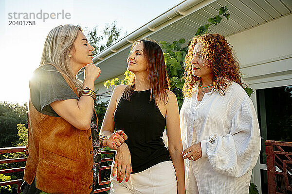 Friends standing together and talking in balcony