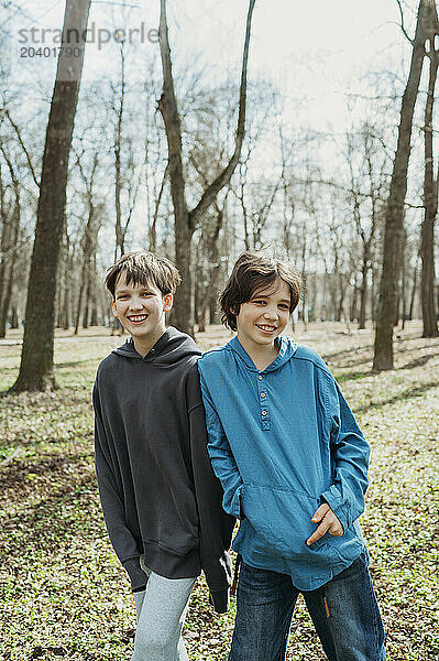 Happy friends standing together at park