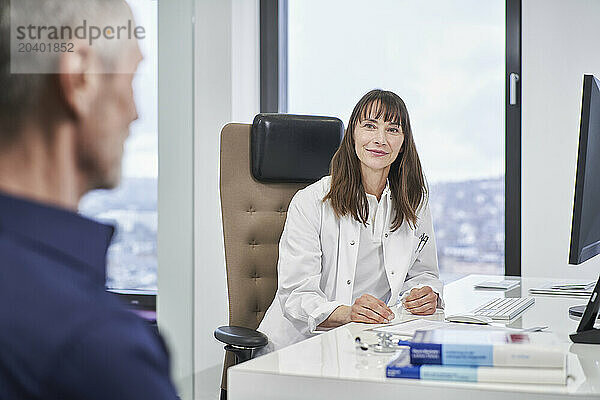 Female doctor looking at senior patient in medical practice