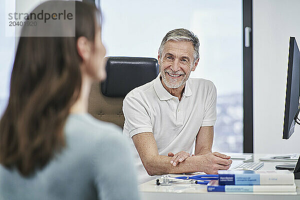 Doctor smiling at female patient in medical practice