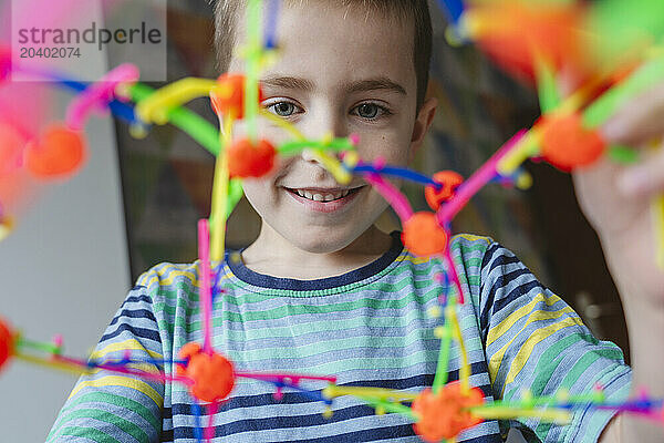 Smiling boy playing with expandable breathing ball at home