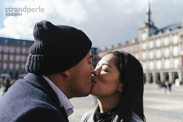 Couple kissing in front of Casa de la Panaderia building  Madrid  Spain