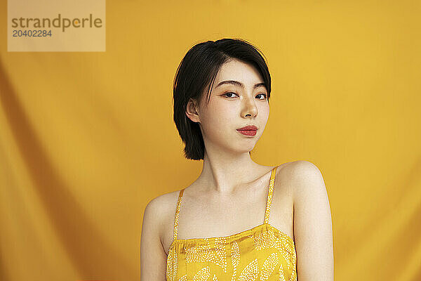 Young woman against yellow background