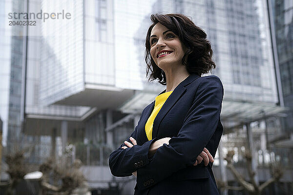 Smiling businesswoman standing with arms crossed